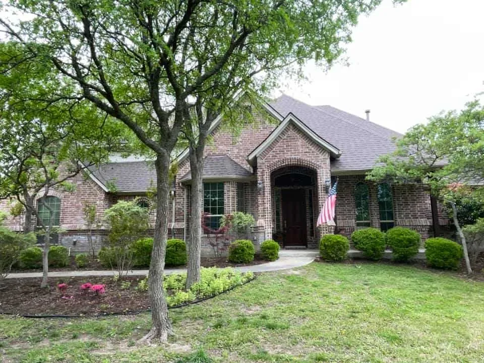 Brick home with a completed gray shingle roof